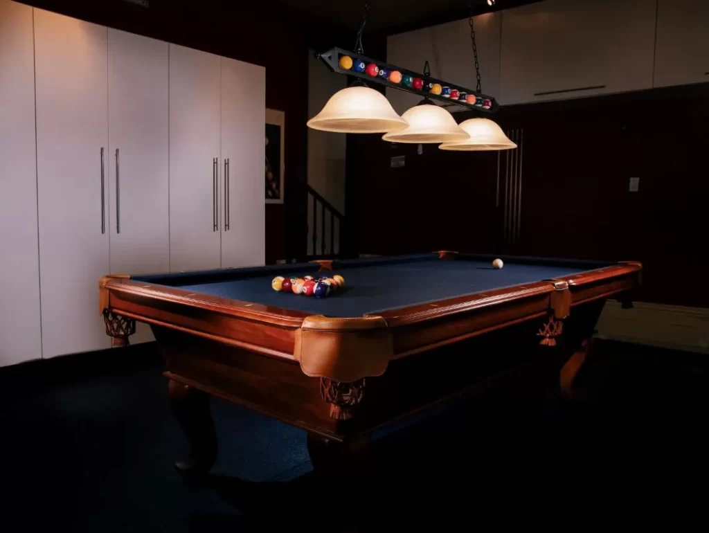 A pool table in a room with ambience lighting.