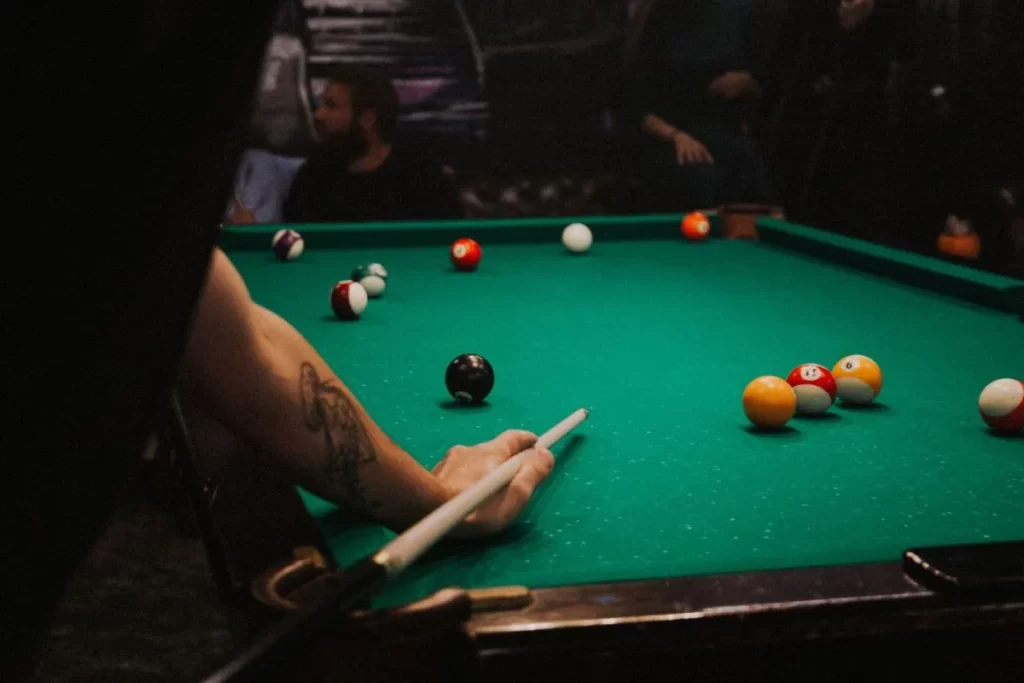A person cueing for a shot on a pool table.